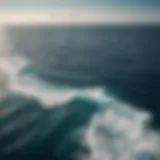 Aerial view of the vast open ocean showcasing its deep blue waters and undulating waves under a bright sky.